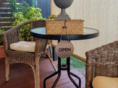 Mackay open sign on table with bird